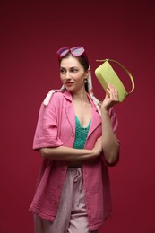Photo of Fashionable portrait of beautiful woman in stylish outfit on dark red background