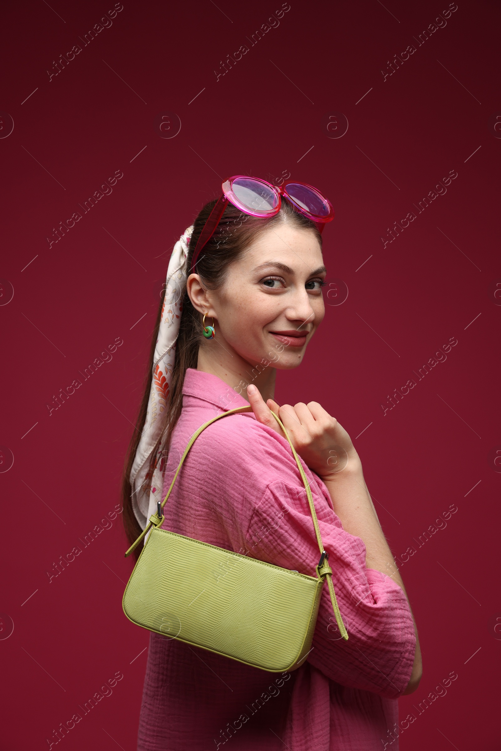 Fashionable portrait of beautiful woman in stylish outfit on dark red background Photo of Fashionable portrait of beautiful woman in stylish outfit on dark red background