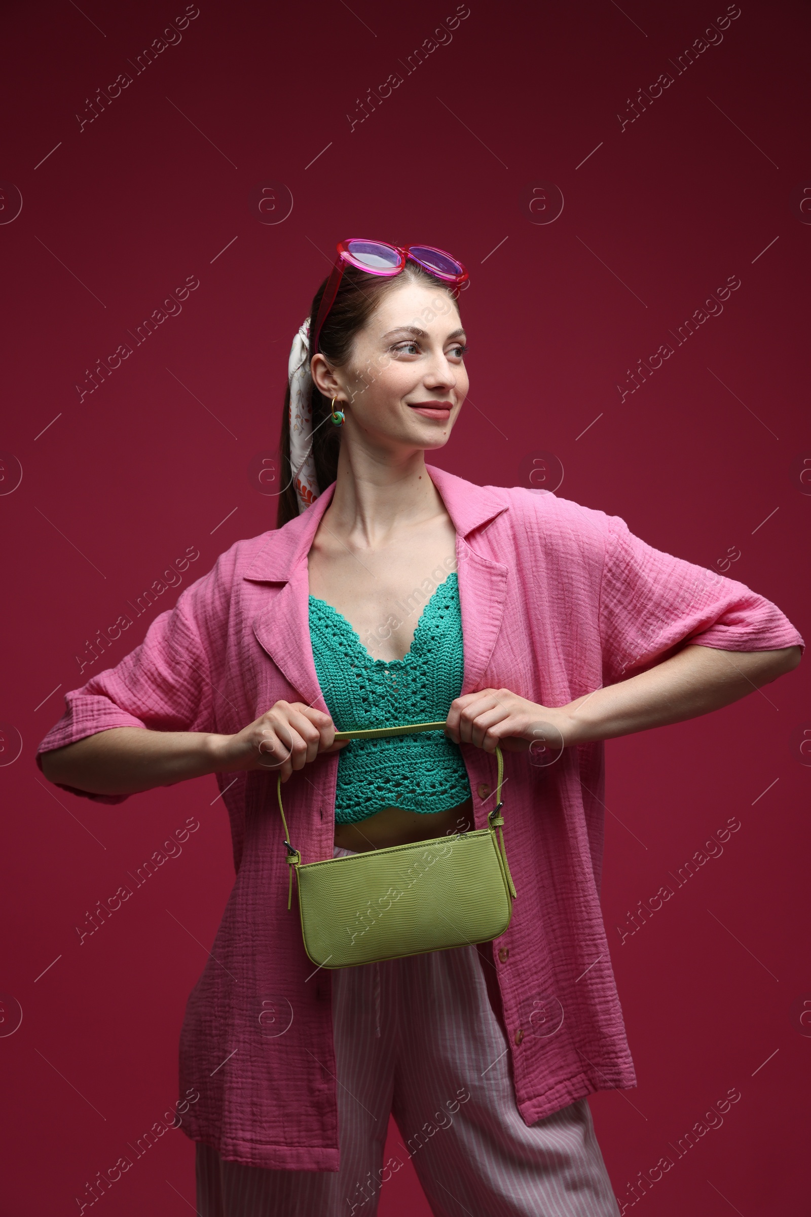 Fashionable portrait of beautiful woman in stylish outfit on dark red background Photo of Fashionable portrait of beautiful woman in stylish outfit on dark red background