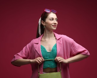 Photo of Fashionable portrait of beautiful woman in stylish outfit on dark red background