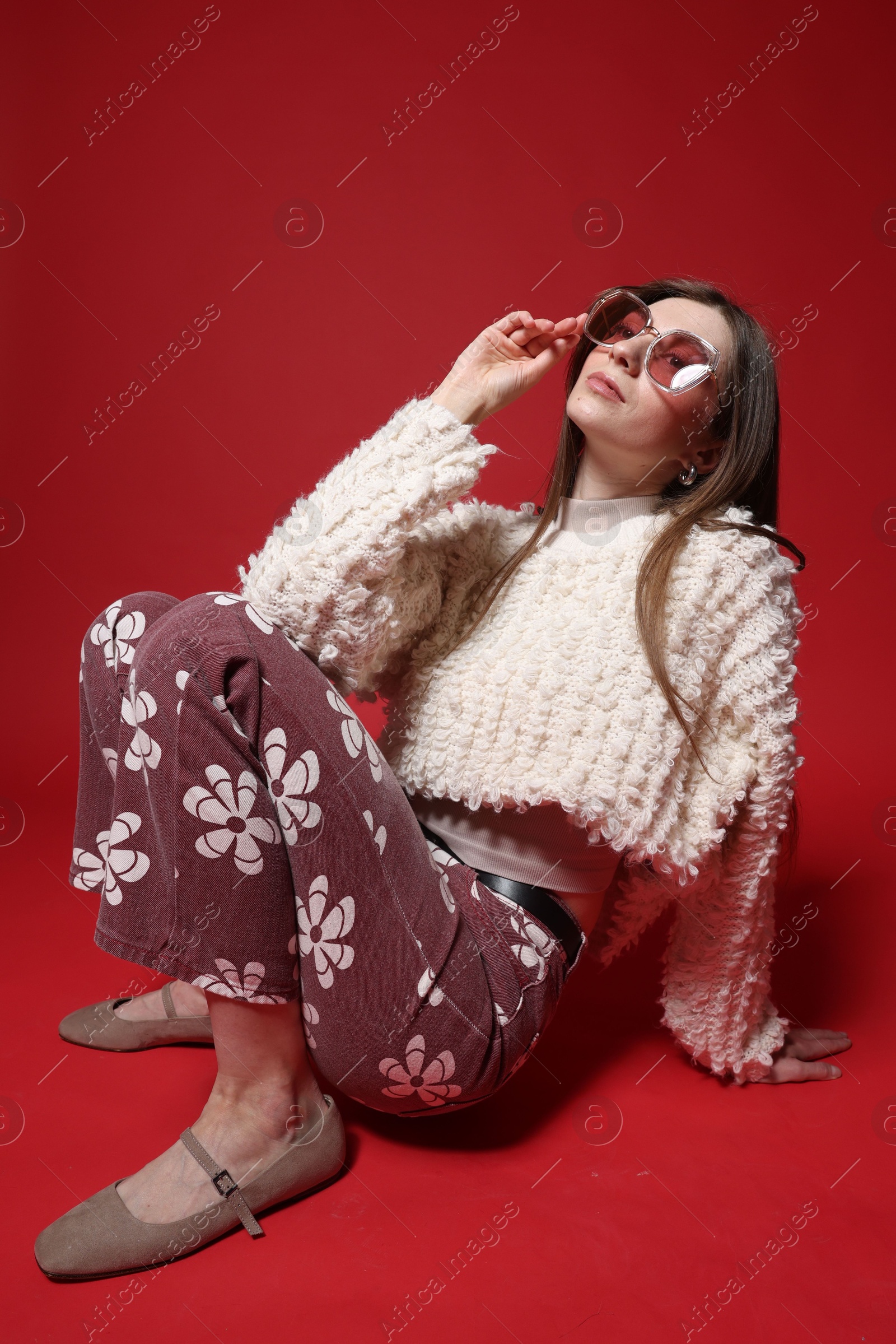 Fashionable portrait of beautiful woman in stylish outfit on red background Photo of Fashionable portrait of beautiful woman in stylish outfit on red background