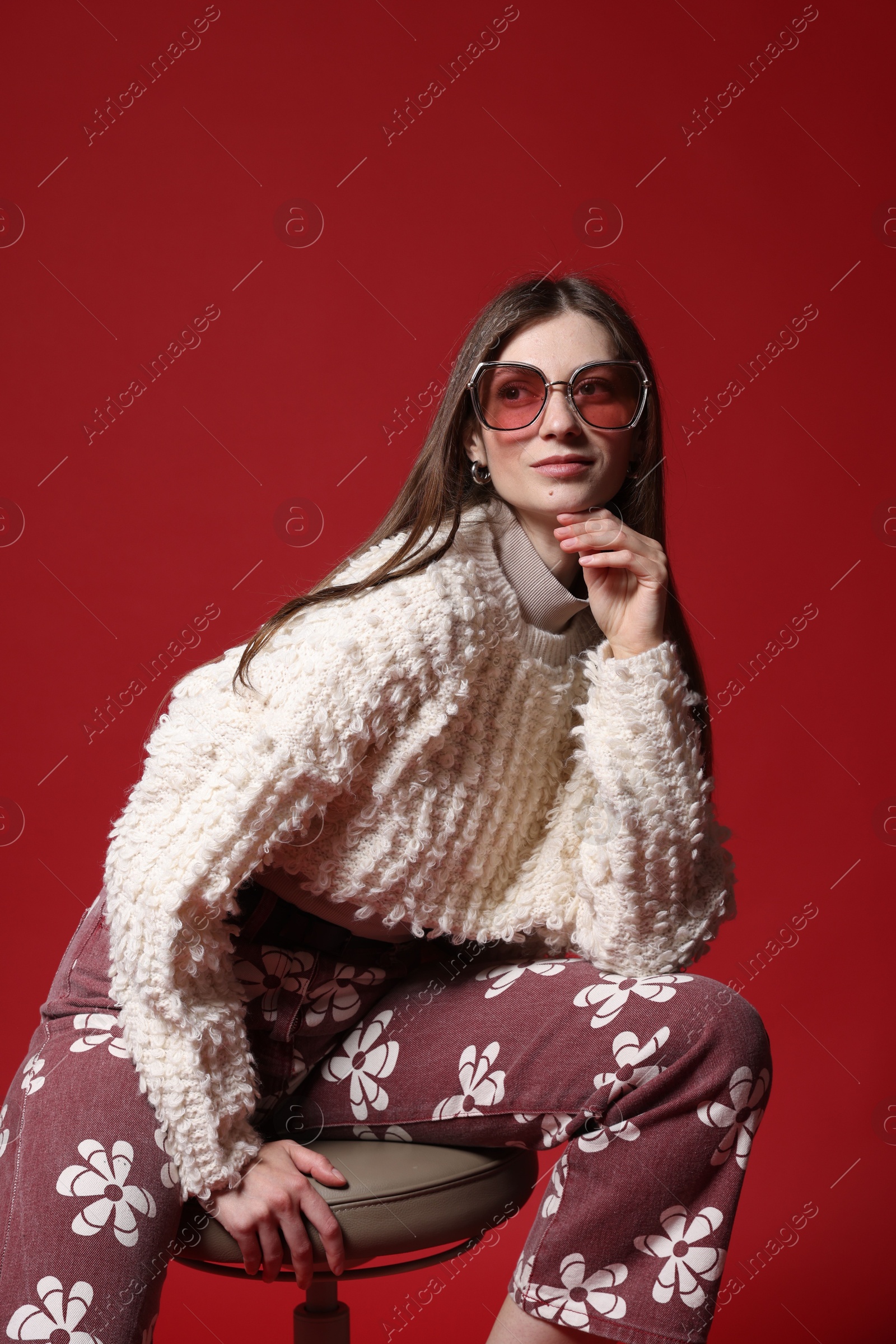 Fashionable portrait of beautiful woman in stylish outfit on red background Photo of Fashionable portrait of beautiful woman in stylish outfit on red background