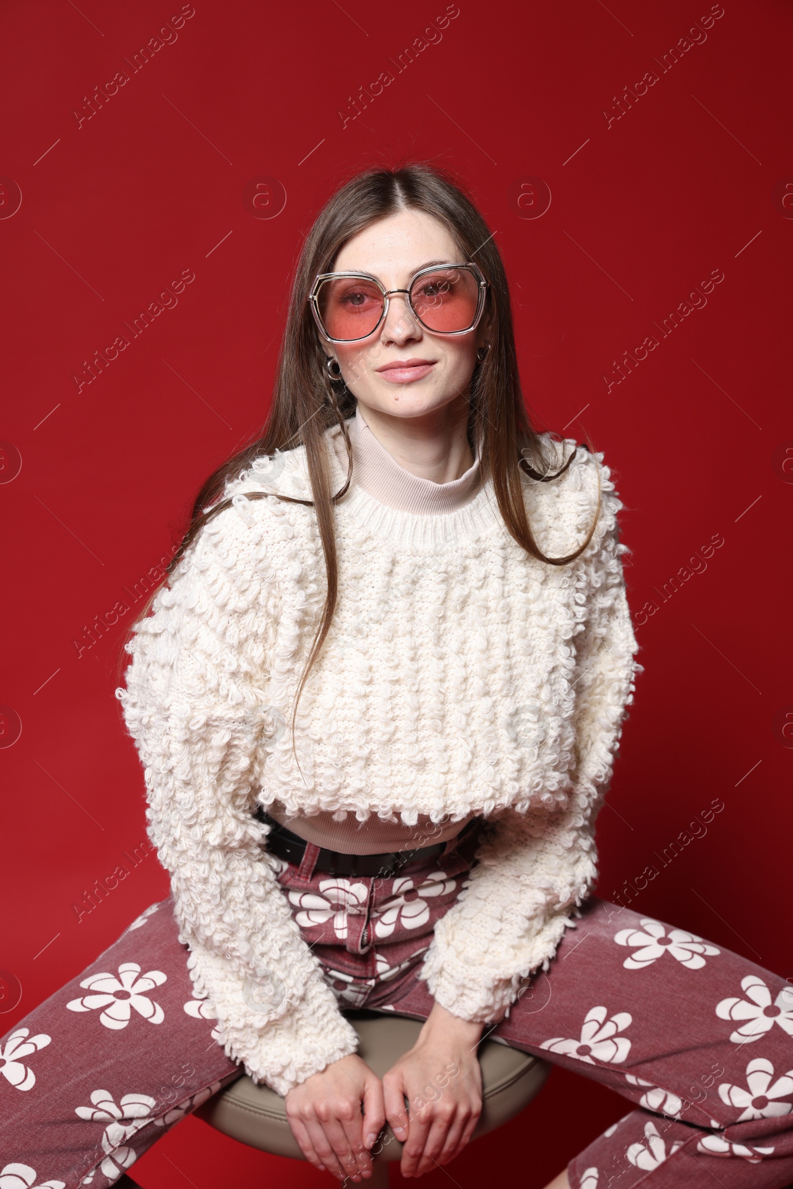Fashionable portrait of beautiful woman in stylish outfit on red background Photo of Fashionable portrait of beautiful woman in stylish outfit on red background