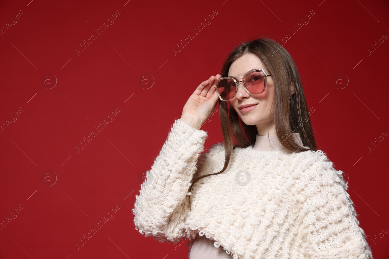 Fashionable portrait of beautiful woman in stylish outfit on red background. Space for text Photo of Fashionable portrait of beautiful woman in stylish outfit on red background. Space for text