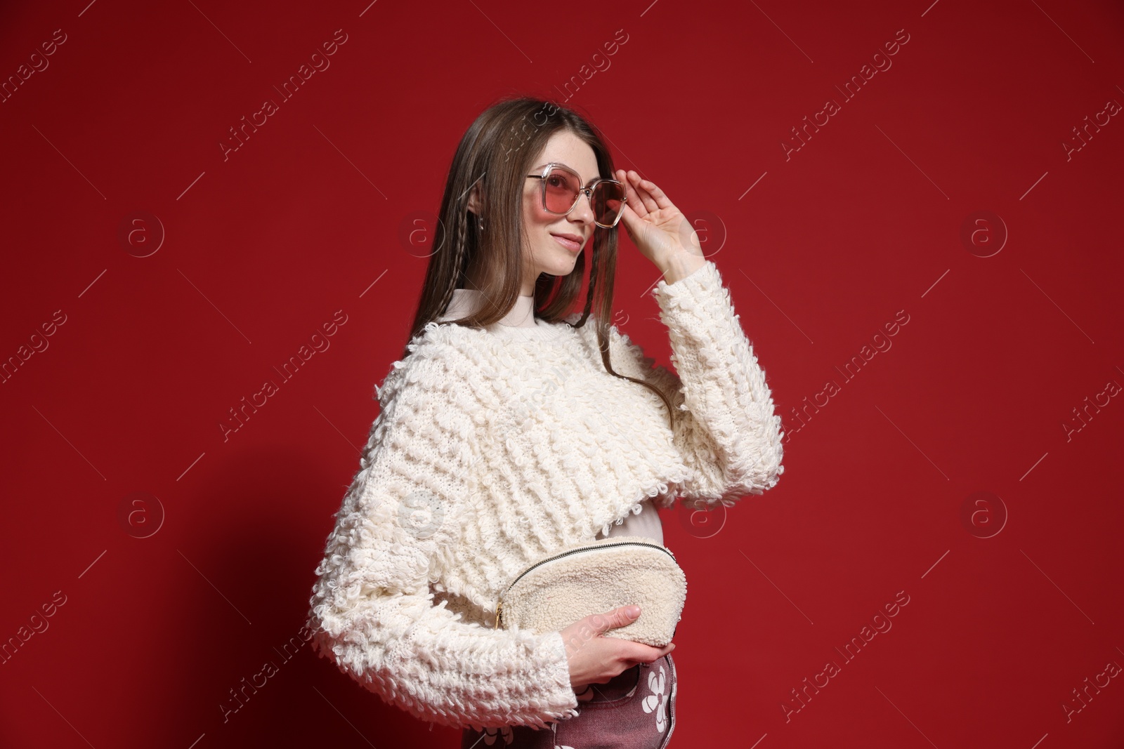 Fashionable portrait of beautiful woman in stylish outfit on red background Photo of Fashionable portrait of beautiful woman in stylish outfit on red background
