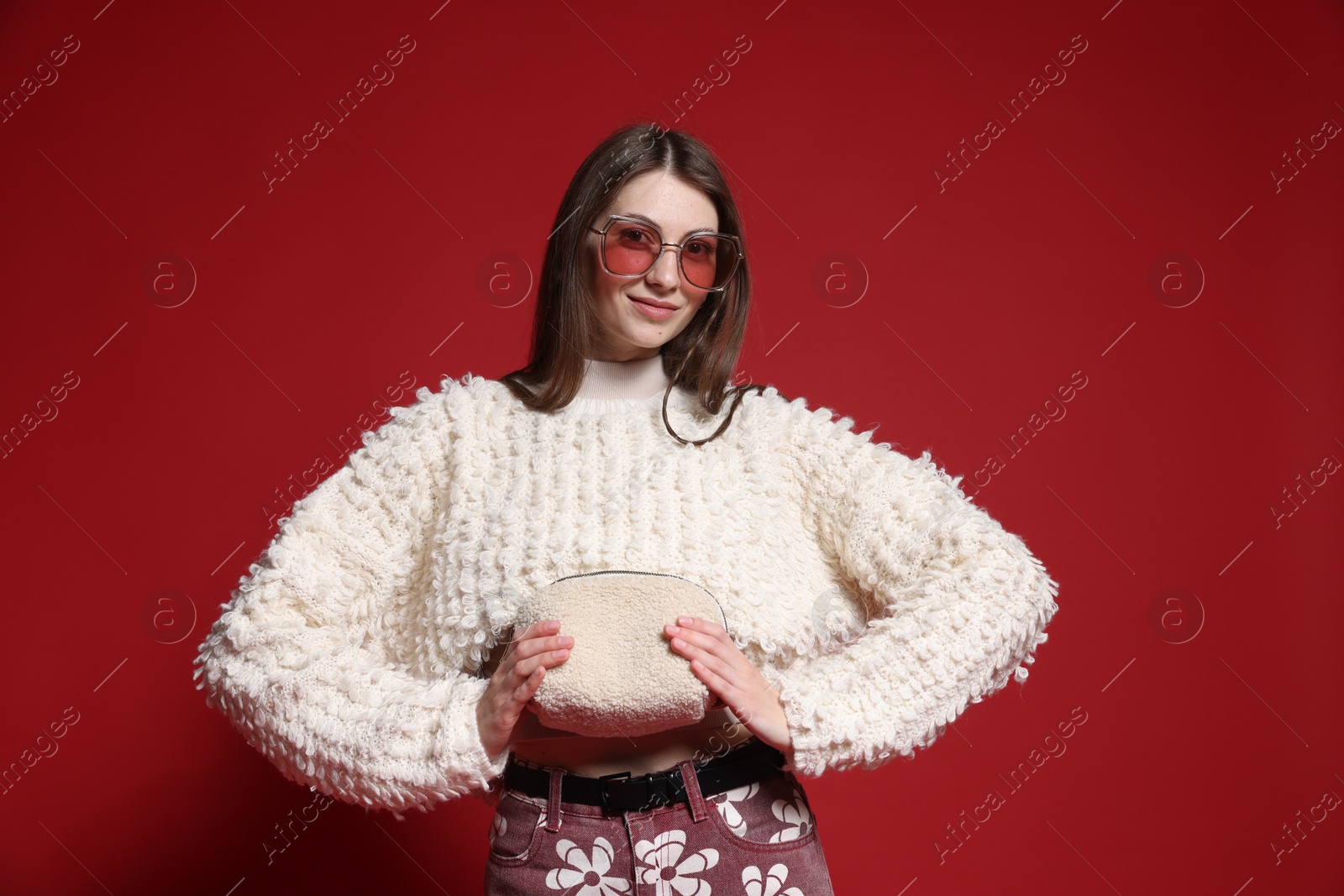 Fashionable portrait of beautiful woman in stylish outfit on red background Photo of Fashionable portrait of beautiful woman in stylish outfit on red background