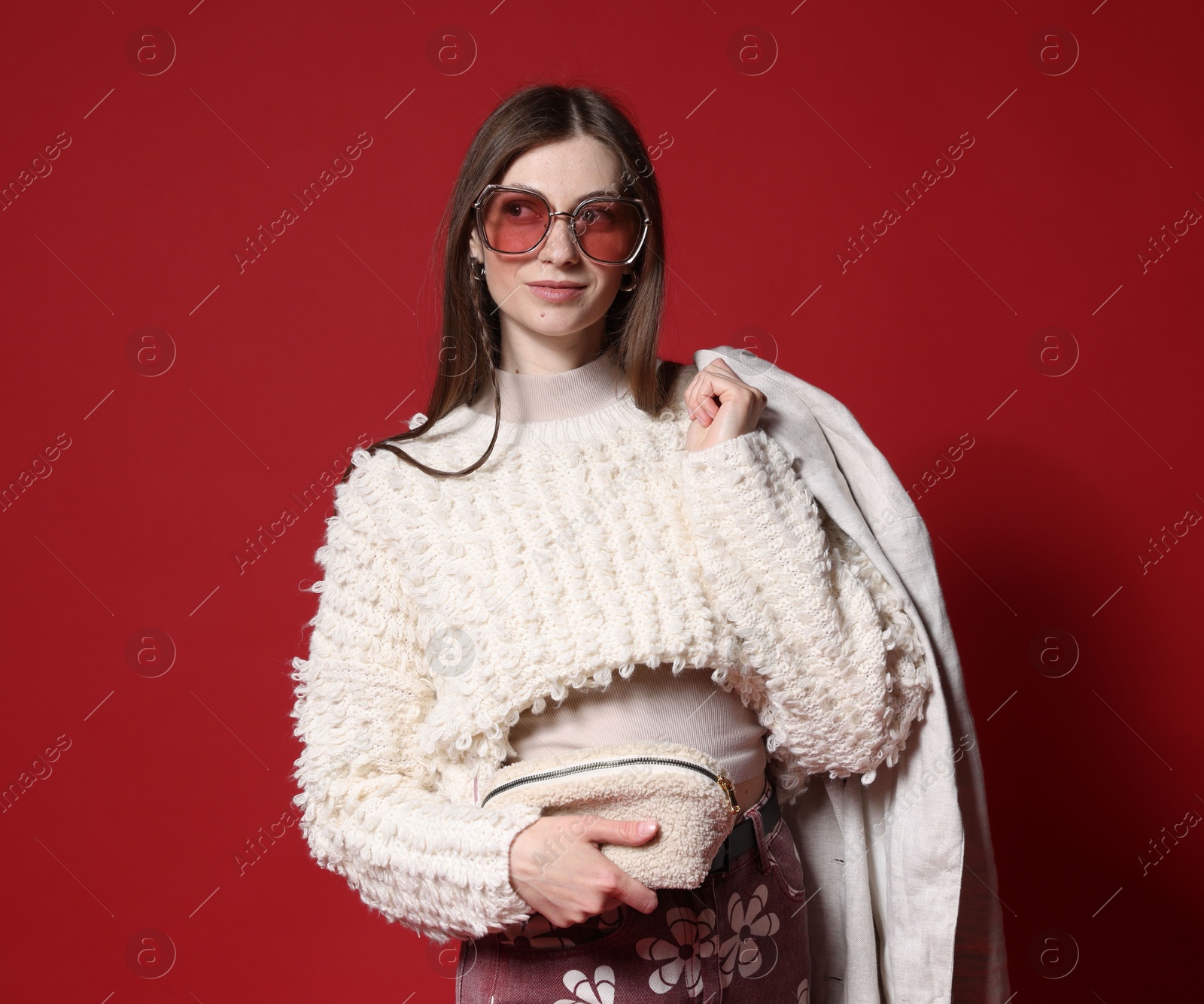 Fashionable portrait of beautiful woman in stylish outfit on red background Photo of Fashionable portrait of beautiful woman in stylish outfit on red background