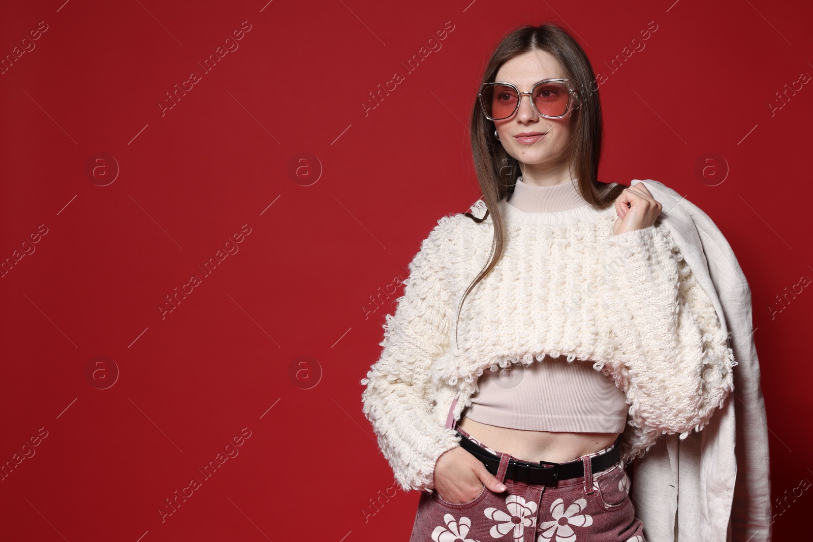 Fashionable portrait of beautiful woman in stylish outfit on red background. Space for text Photo of Fashionable portrait of beautiful woman in stylish outfit on red background. Space for text