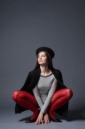 Photo of Fashionable portrait of beautiful woman in stylish outfit on grey background. Space for text