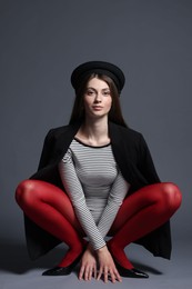 Photo of Fashionable portrait of beautiful woman in stylish outfit on grey background