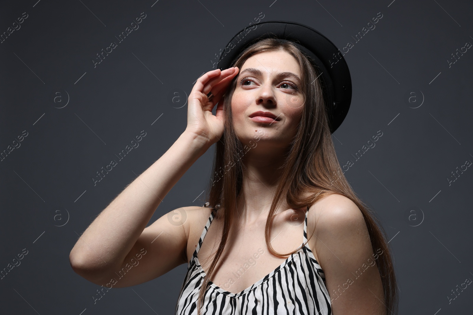 Fashionable portrait of beautiful woman in stylish outfit on grey background Photo of Fashionable portrait of beautiful woman in stylish outfit on grey background