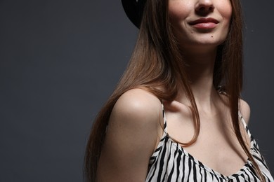 Photo of Woman in stylish outfit on grey background, closeup. Space for text