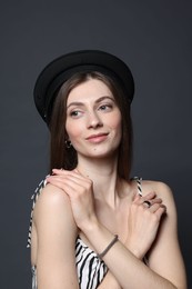 Photo of Fashionable portrait of beautiful woman in stylish outfit on grey background