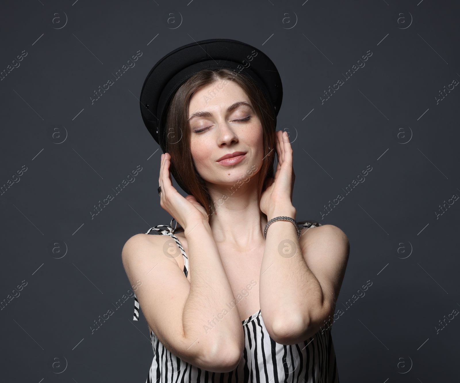 Fashionable portrait of beautiful woman in stylish outfit on grey background Photo of Fashionable portrait of beautiful woman in stylish outfit on grey background