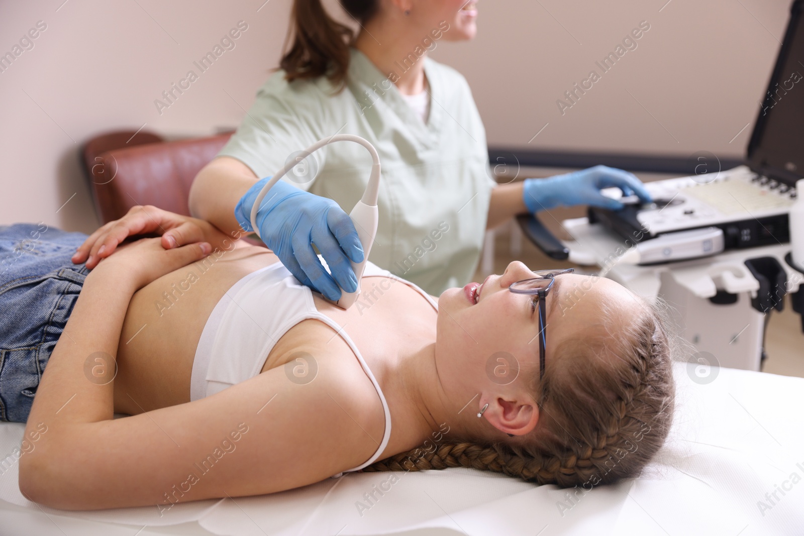 Sonographer conducting ultrasound examination of girl's heart in clinic, closeup Photo of Sonographer conducting ultrasound examination of girl's heart in clinic, closeup