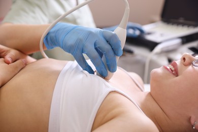 Photo of Sonographer conducting ultrasound examination of girl's heart in clinic, closeup