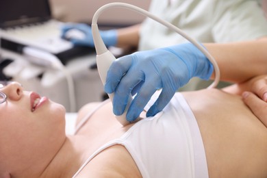 Photo of Sonographer conducting ultrasound examination of girl's heart in clinic, closeup