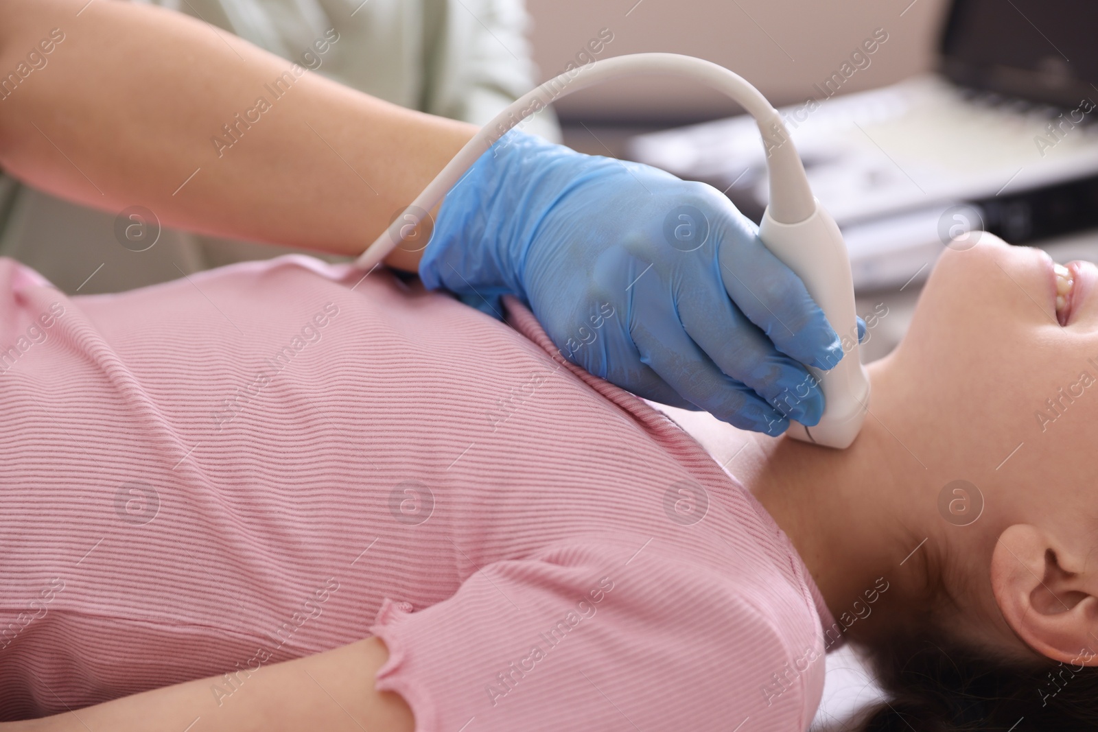 Sonographer conducting girl's thyroid gland ultrasound examination in clinic, closeup Photo of Sonographer conducting girl's thyroid gland ultrasound examination in clinic, closeup