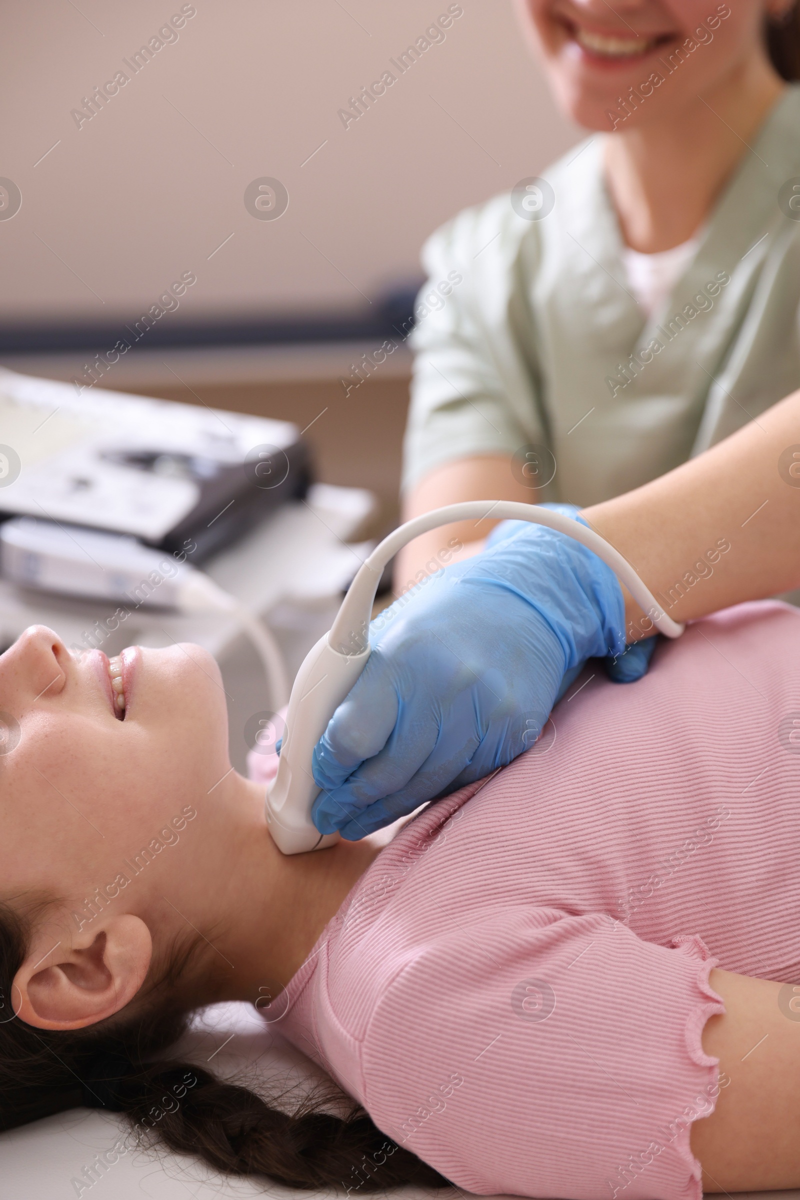 Sonographer conducting girl's thyroid gland ultrasound examination in clinic, closeup Photo of Sonographer conducting girl's thyroid gland ultrasound examination in clinic, closeup