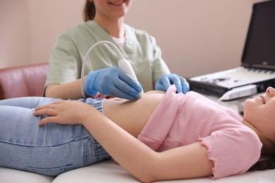 Photo of Sonographer conducting girl's abdominal ultrasound examination in clinic, closeup