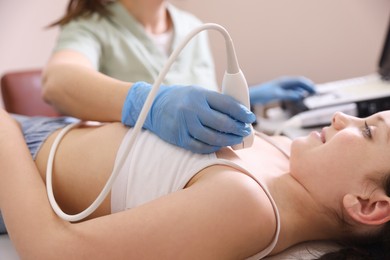 Photo of Sonographer conducting ultrasound examination of girl's heart in clinic, closeup
