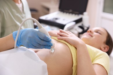 Photo of Sonographer conducting girl's abdominal ultrasound examination in clinic, closeup