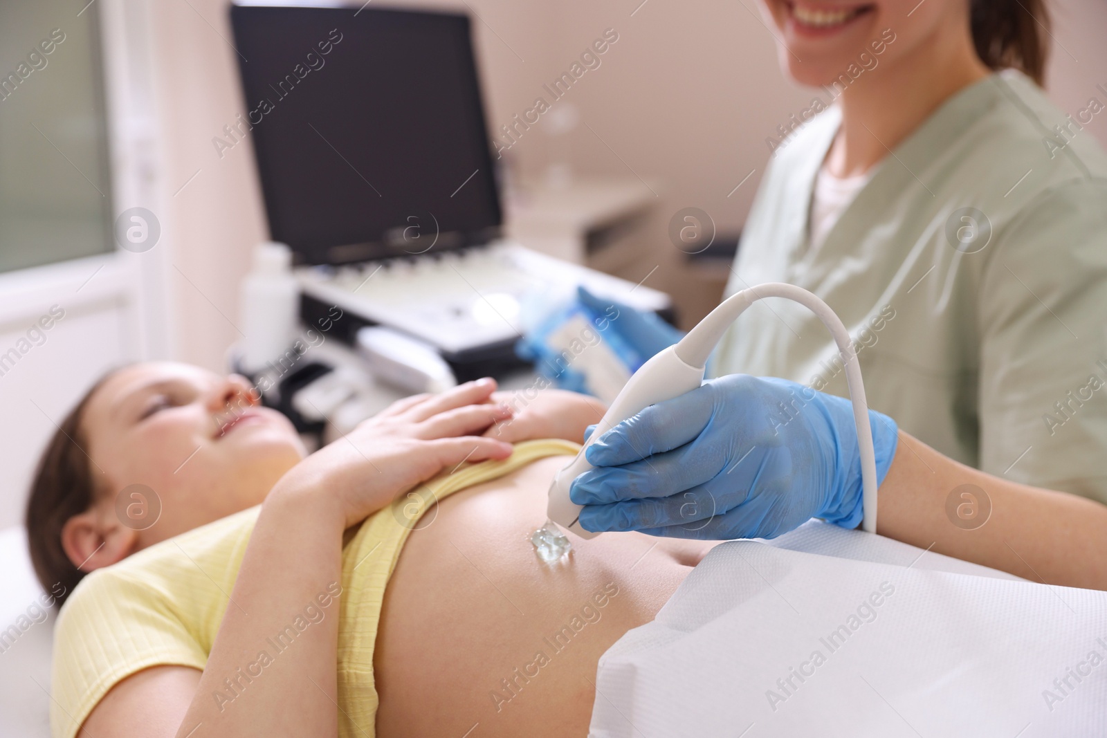 Sonographer conducting girl's abdominal ultrasound examination in clinic, closeup Photo of Sonographer conducting girl's abdominal ultrasound examination in clinic, closeup