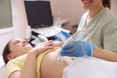Photo of Sonographer conducting girl's abdominal ultrasound examination in clinic, closeup