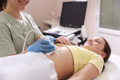 Photo of Sonographer conducting girl's abdominal ultrasound examination in clinic, closeup