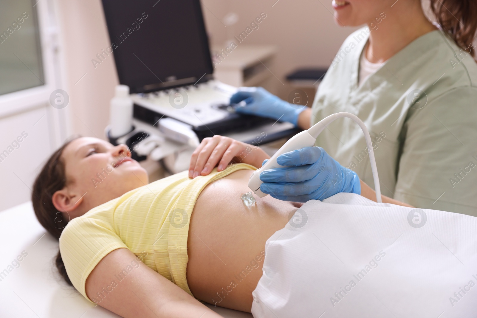 Sonographer conducting girl's abdominal ultrasound examination in clinic, closeup Photo of Sonographer conducting girl's abdominal ultrasound examination in clinic, closeup