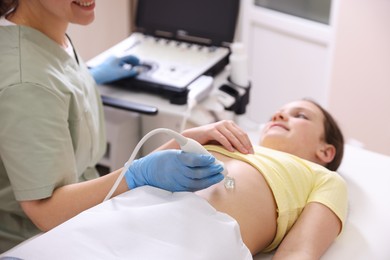 Photo of Sonographer conducting girl's abdominal ultrasound examination in clinic, closeup