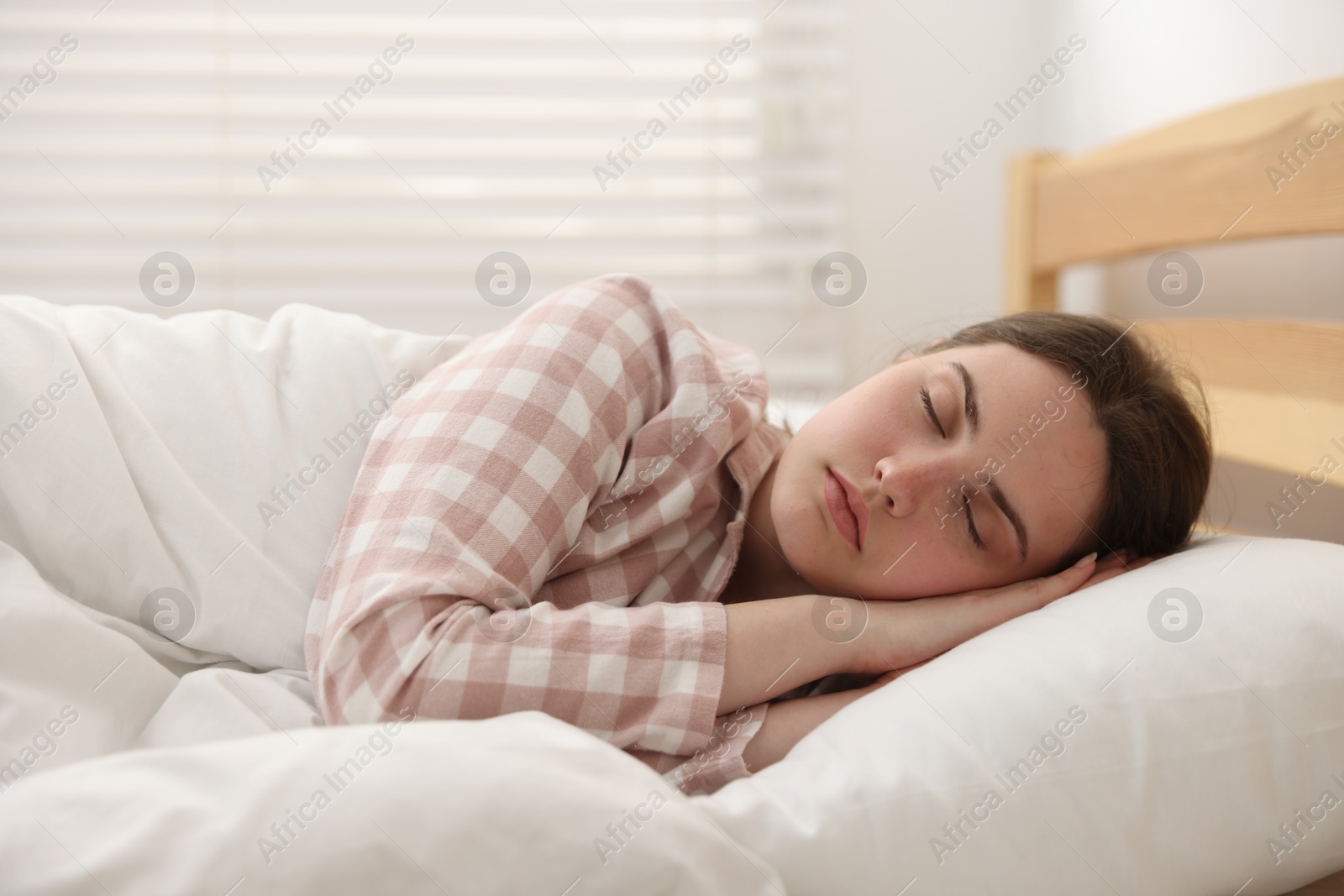 Young woman sleeping on bed at home Photo of Young woman sleeping on bed at home