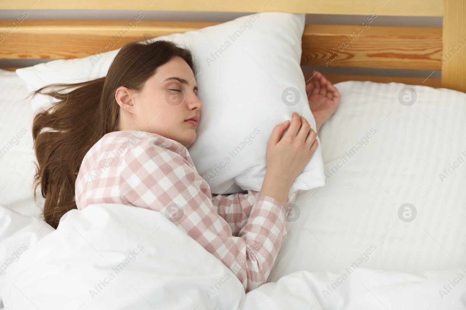 Young woman sleeping on bed at home, above view Photo of Young woman sleeping on bed at home, above view