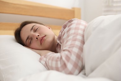 Photo of Young woman sleeping on bed at home