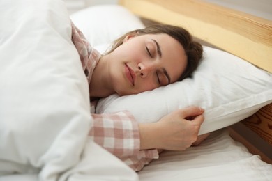 Photo of Young woman sleeping on bed at home