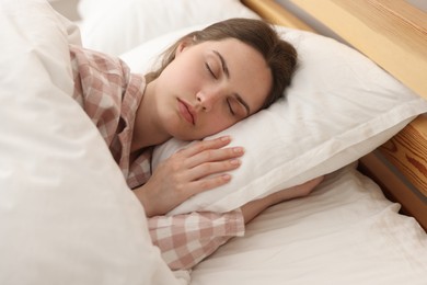 Photo of Young woman sleeping on bed at home