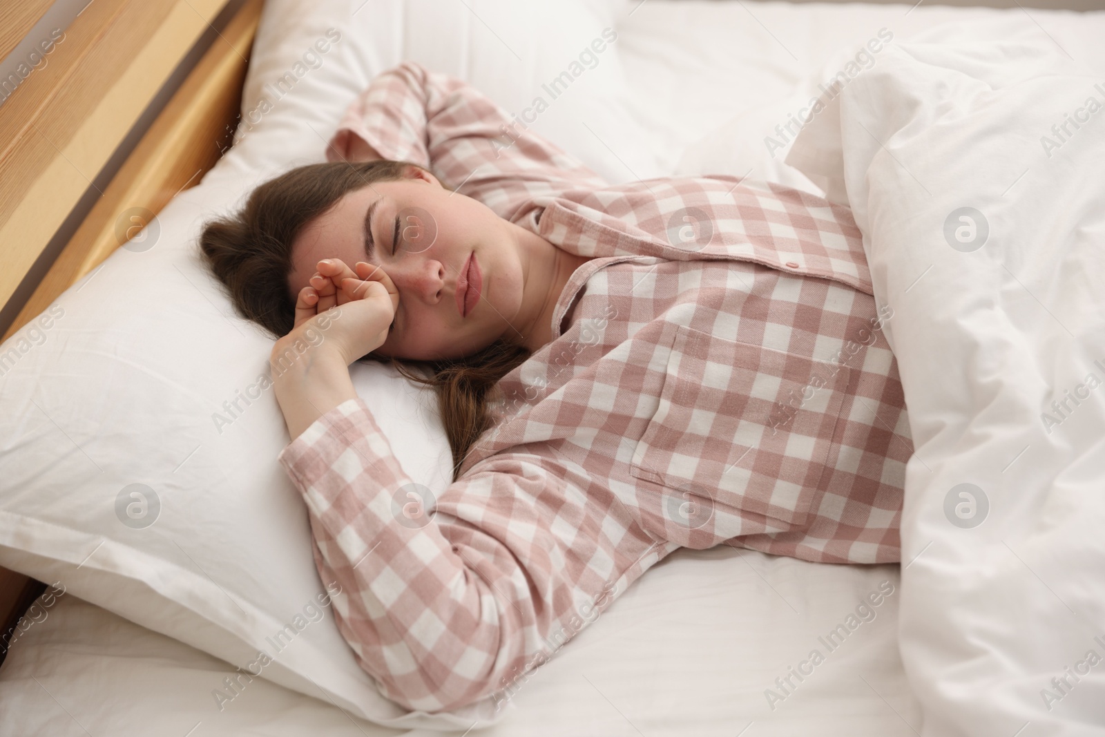 Young woman sleeping on bed at home Photo of Young woman sleeping on bed at home