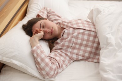 Photo of Young woman sleeping on bed at home