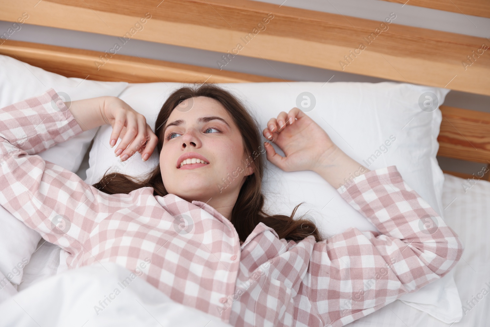 Young woman stretching on bed at home Photo of Young woman stretching on bed at home