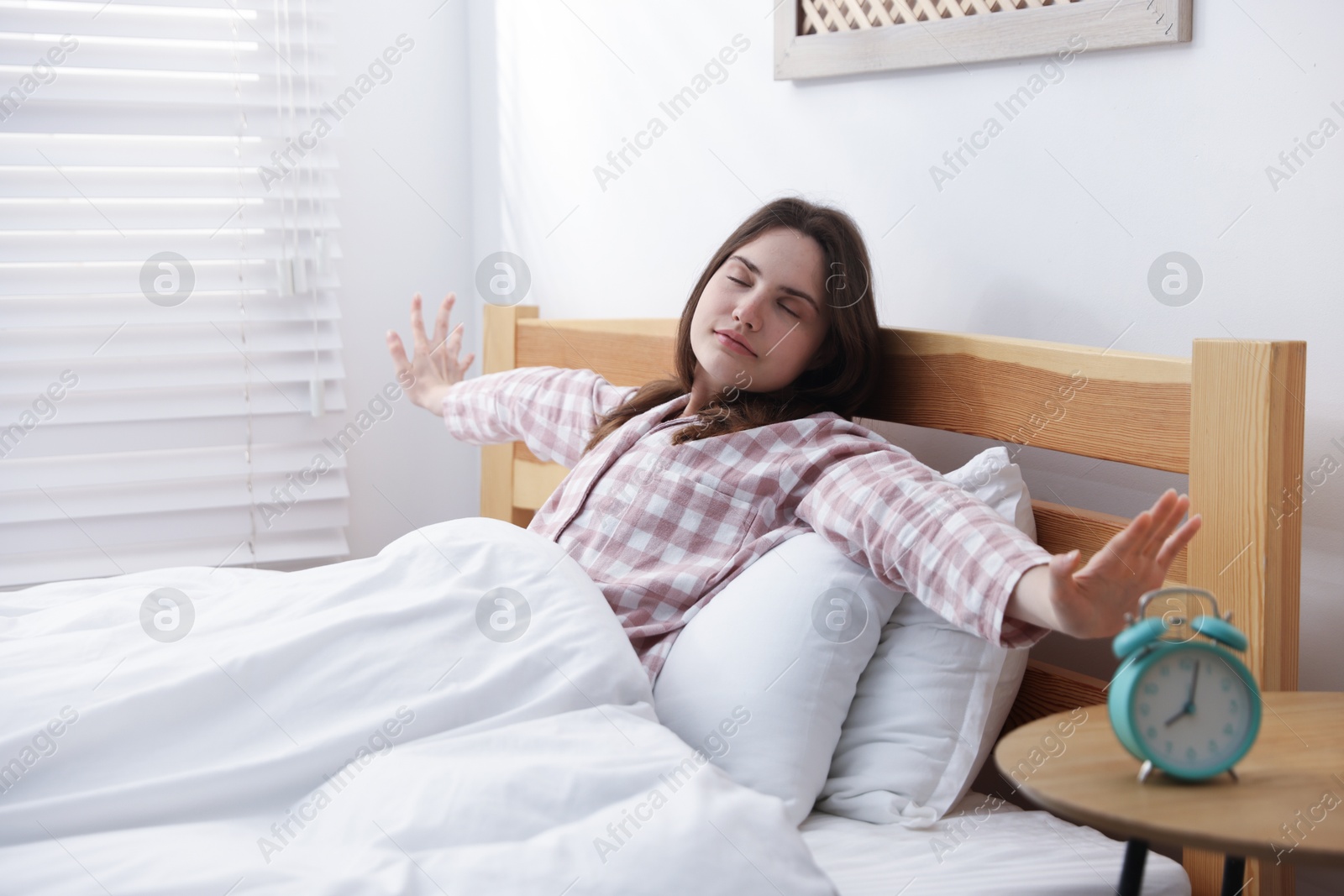 Young woman stretching on bed at home Photo of Young woman stretching on bed at home