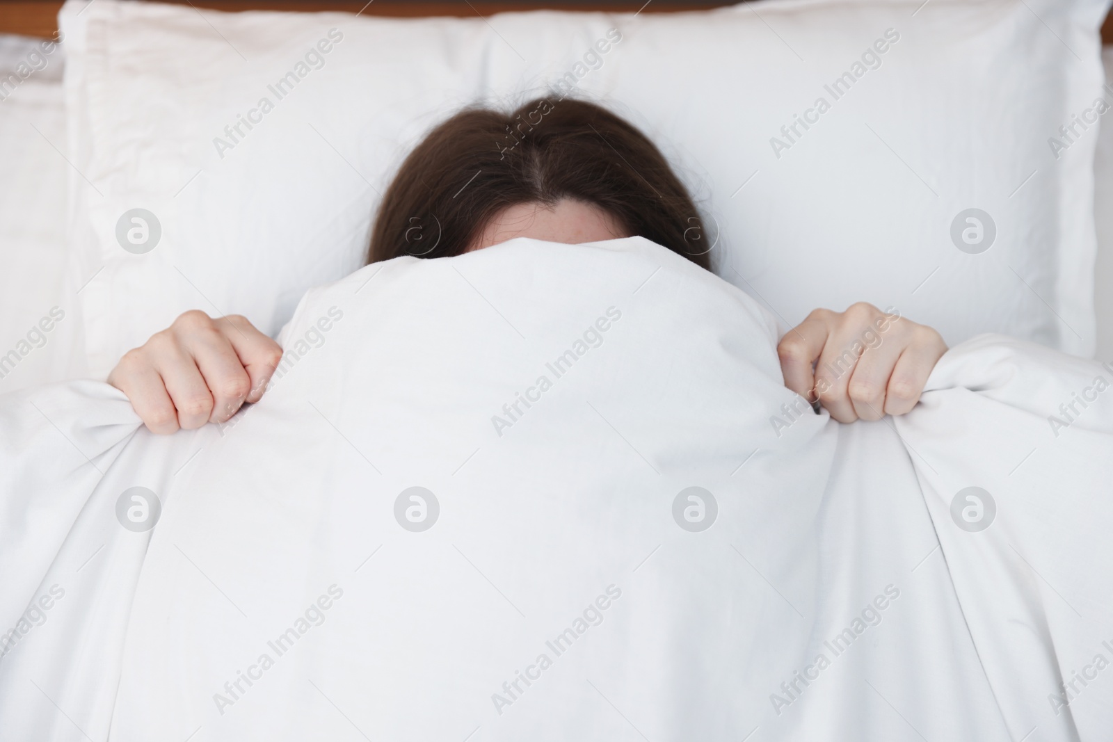 Woman covering herself with blanket on bed at home, above view. Insomnia problem Photo of Woman covering herself with blanket on bed at home, above view. Insomnia problem