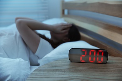 Photo of Frustrated young woman suffering from insomnia on bed indoors, selective focus