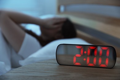 Photo of Frustrated young woman suffering from insomnia on bed indoors, selective focus