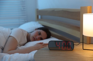 Photo of Frustrated young woman suffering from insomnia on bed indoors, selective focus