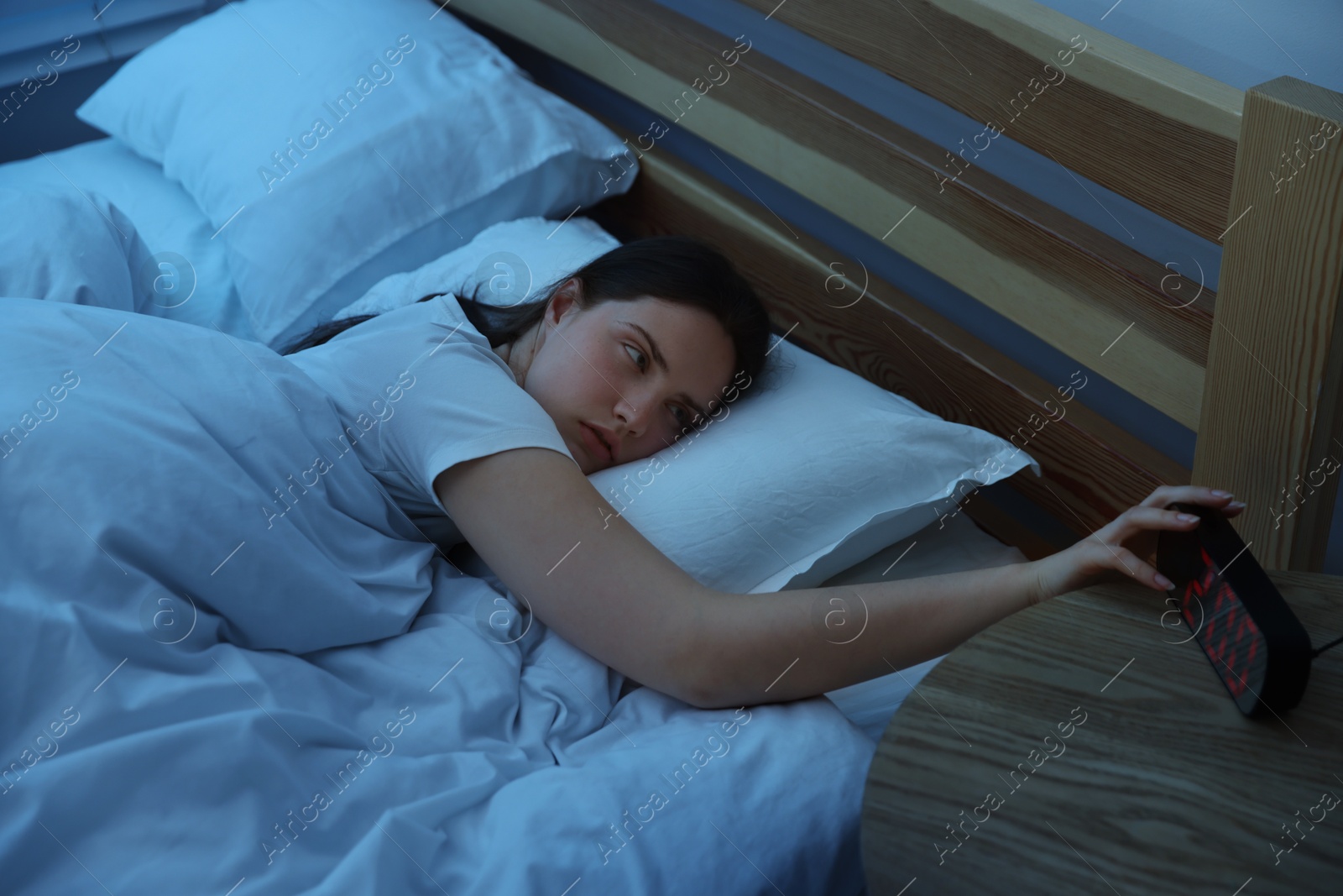Frustrated young woman suffering from insomnia on bed indoors Photo of Frustrated young woman suffering from insomnia on bed indoors