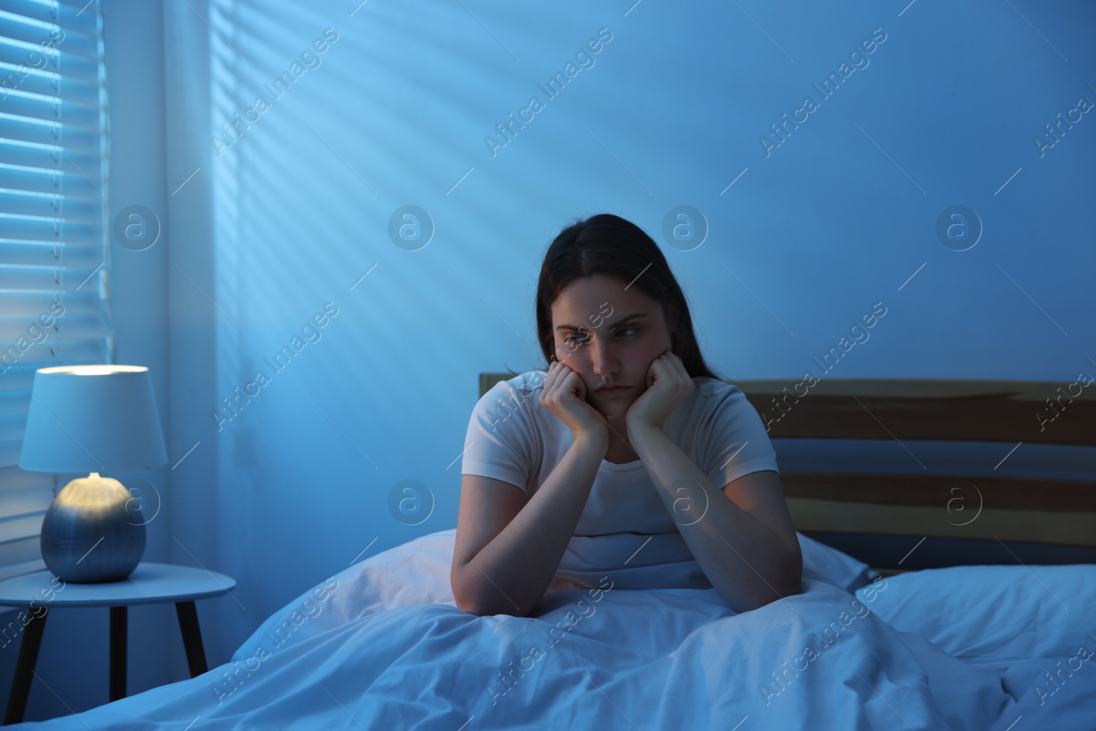 Frustrated young woman suffering from insomnia on bed indoors Photo of Frustrated young woman suffering from insomnia on bed indoors
