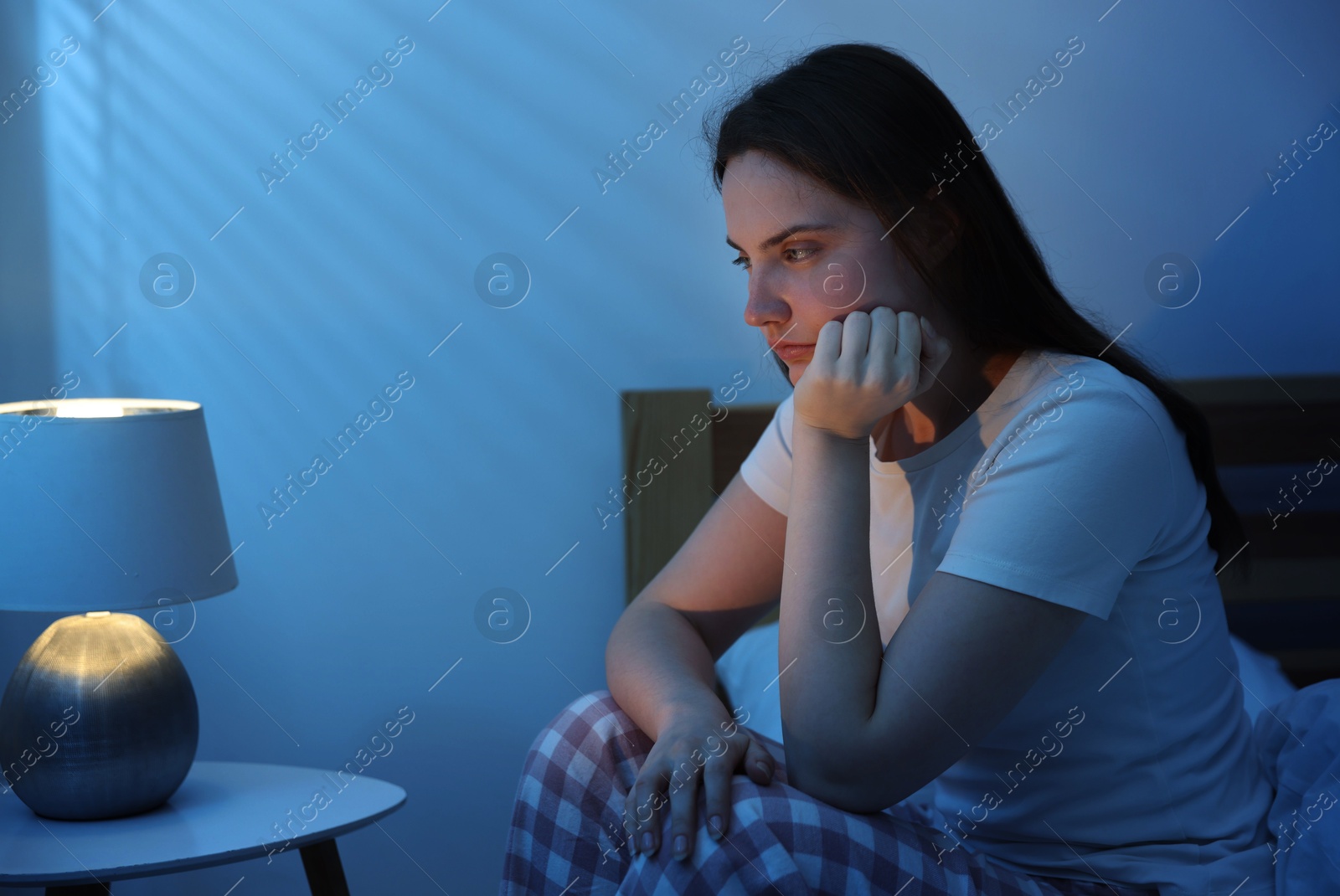 Frustrated young woman suffering from insomnia on bed indoors Photo of Frustrated young woman suffering from insomnia on bed indoors