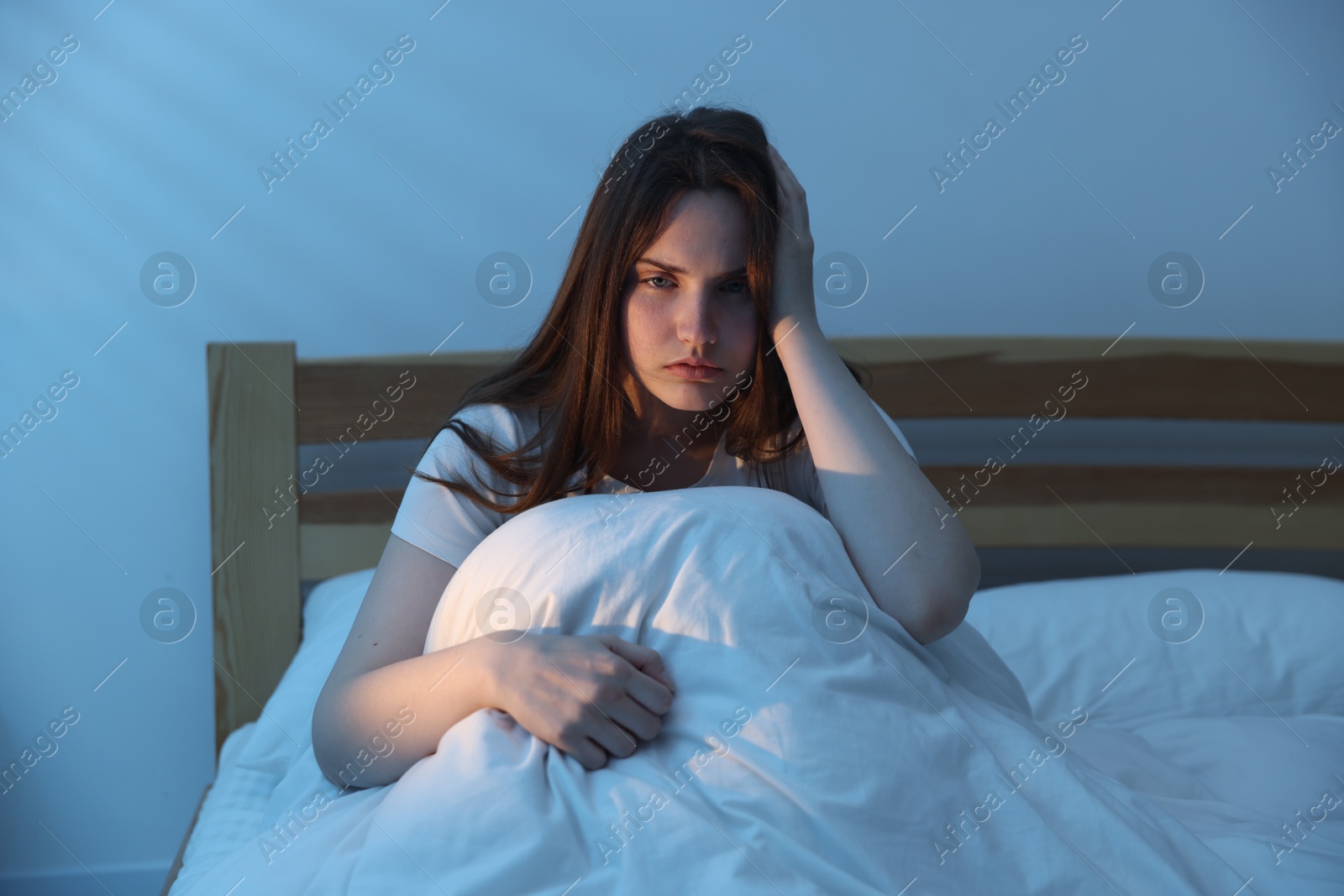 Frustrated young woman suffering from insomnia on bed indoors Photo of Frustrated young woman suffering from insomnia on bed indoors
