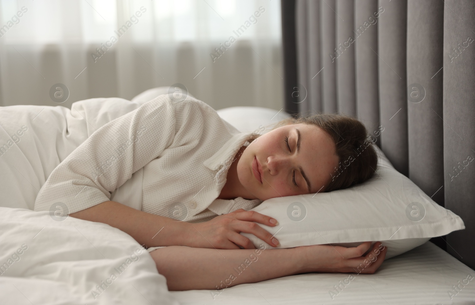 Young woman sleeping on bed at home Photo of Young woman sleeping on bed at home