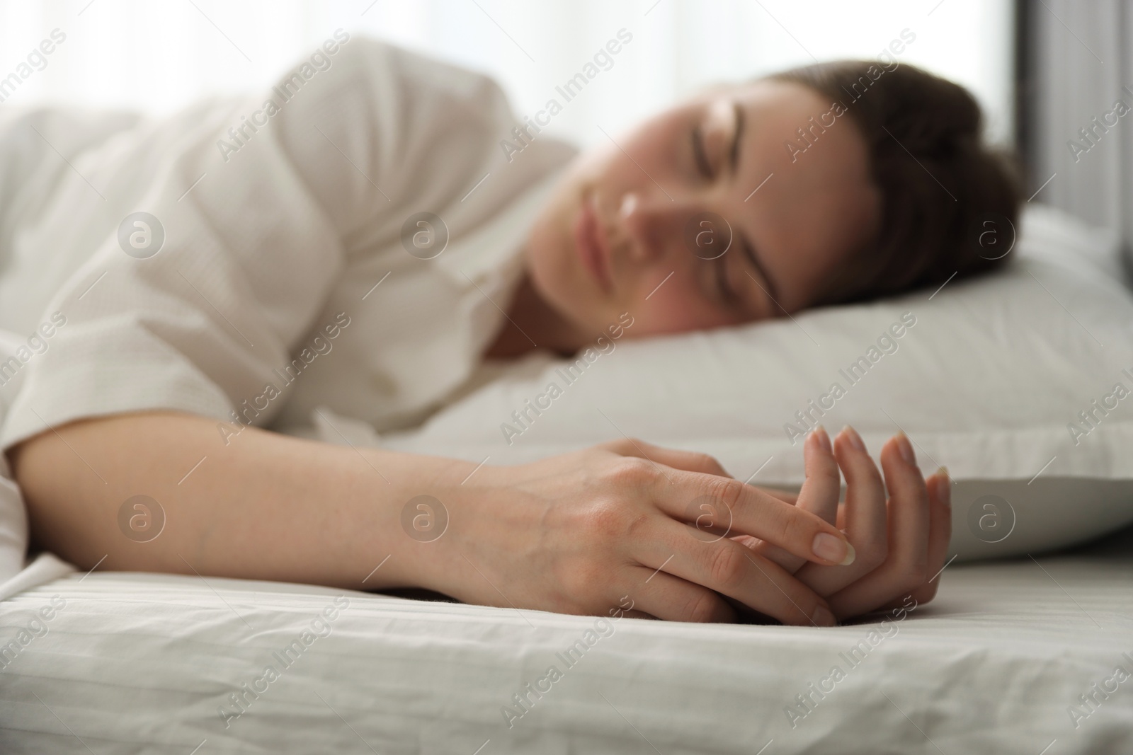 Young woman sleeping on bed at home, selective focus Photo of Young woman sleeping on bed at home, selective focus